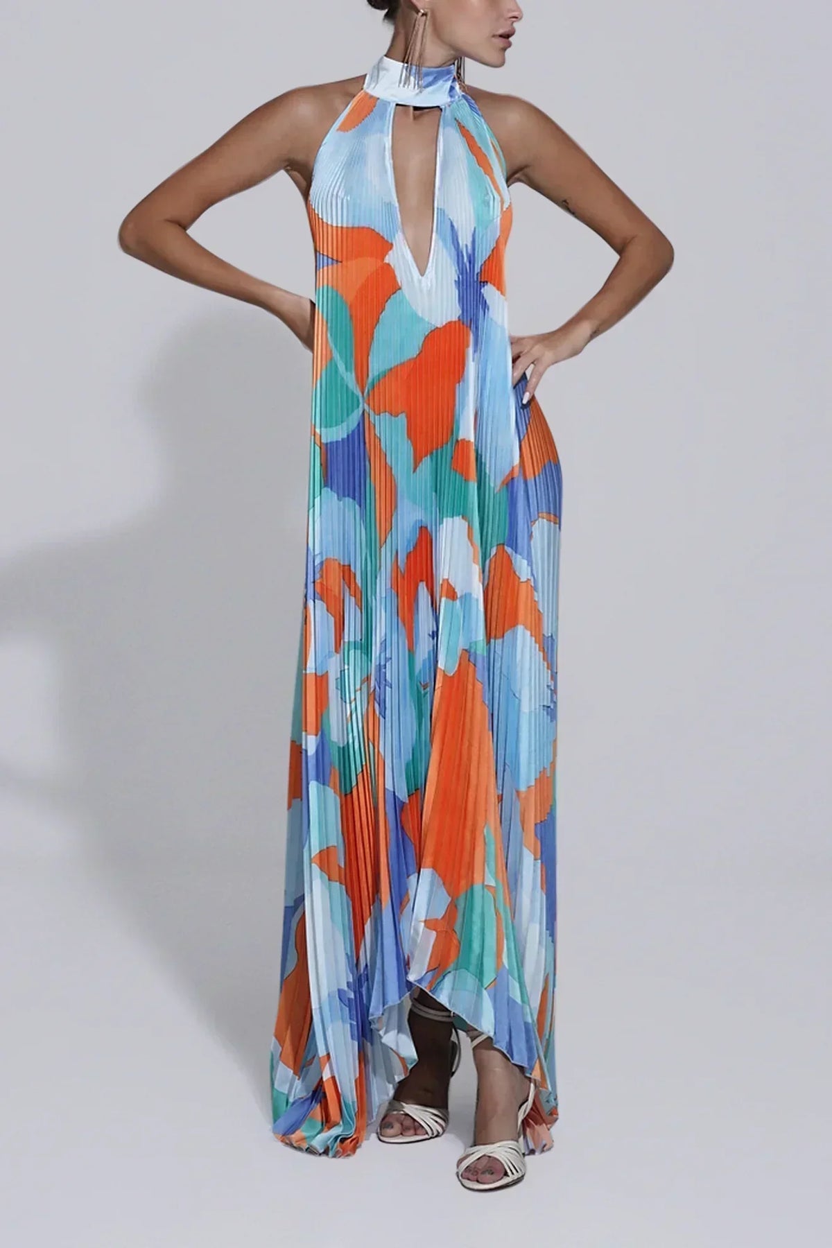 Pleated halter maxi dress in an orange and blue abstract print with keyhole neckline and open back