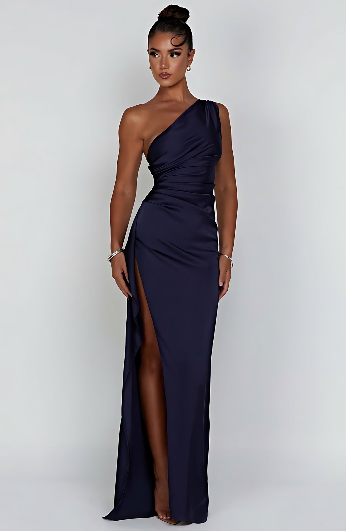 Woman wearing a one shoulder satin formal maxi dress with ruched waist and high thigh split - view 17
