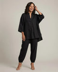 Woman in a black batwing V-neck tunic and cuffed pants matching set