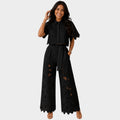 Woman wearing a floral lace two piece set with cropped collared shirt and tie-waist wide leg pants