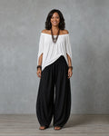 Woman in an off shoulder two piece set with split sleeves and balloon wide leg pants