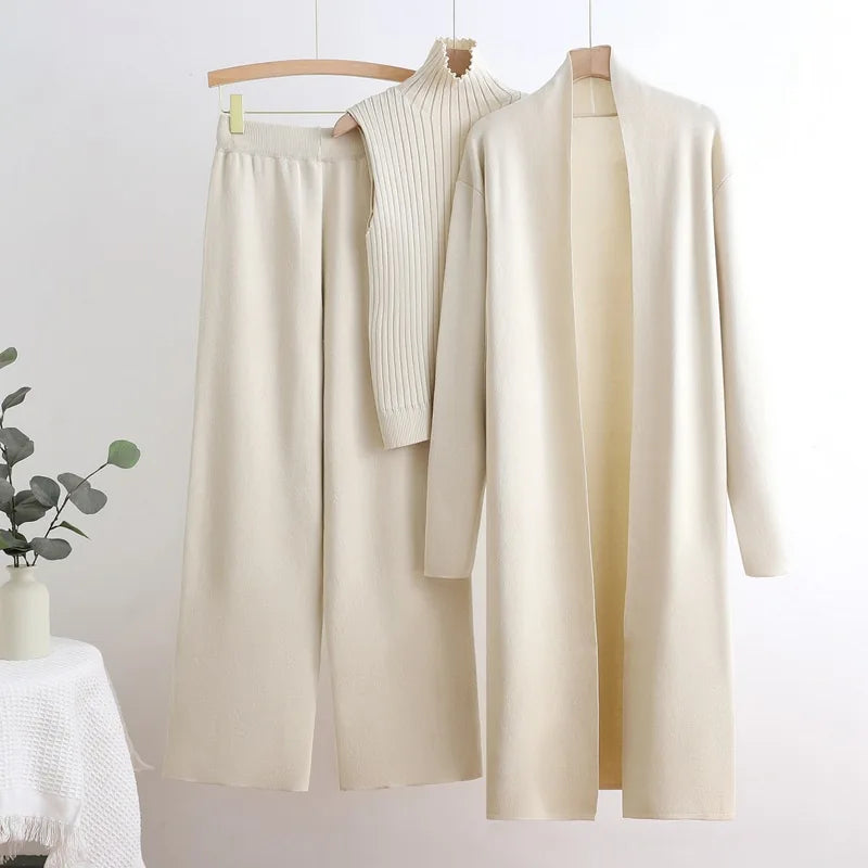 Woman wearing a three piece knit set with longline cardigan, ribbed mock-neck top and wide leg pants - view 11