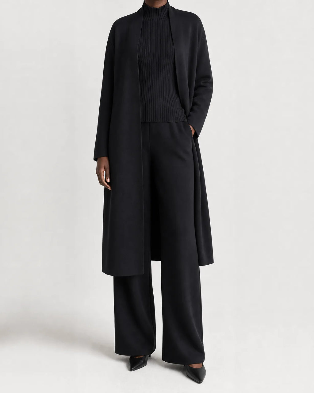 Woman wearing a three piece knit set with longline cardigan, ribbed mock-neck top and wide leg pants - view 2