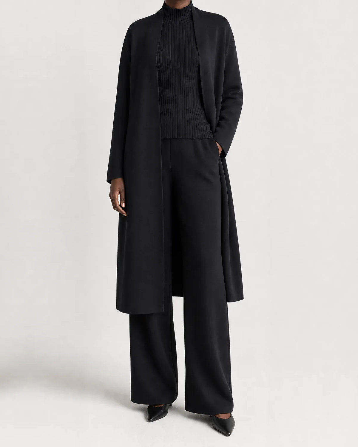 Woman wearing a three piece knit set with longline cardigan, ribbed mock-neck top and wide leg pants - view 2
