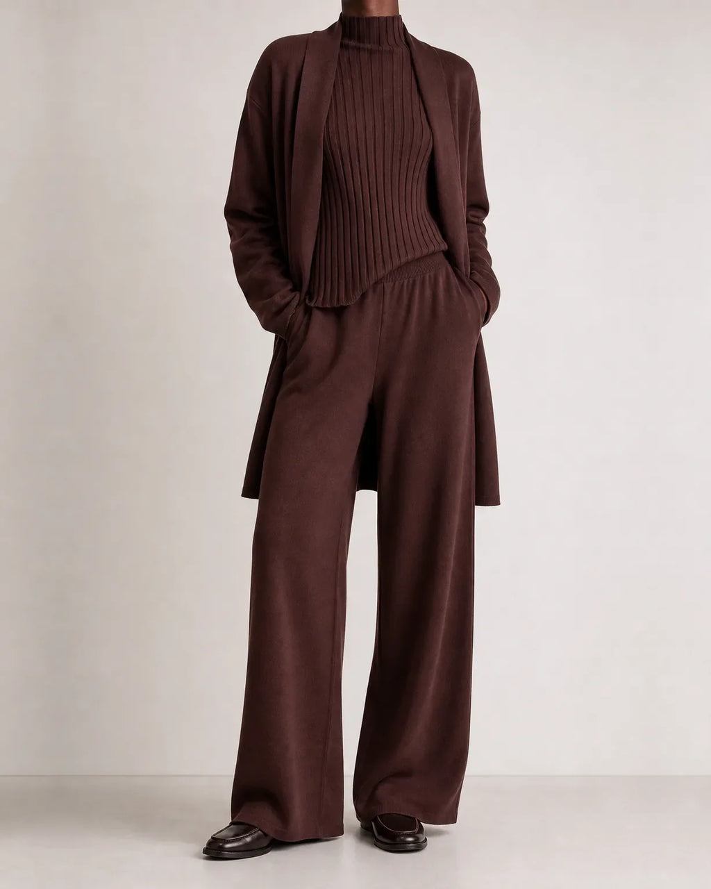 Woman wearing a three piece knit set with longline cardigan, ribbed mock-neck top and wide leg pants - view 3