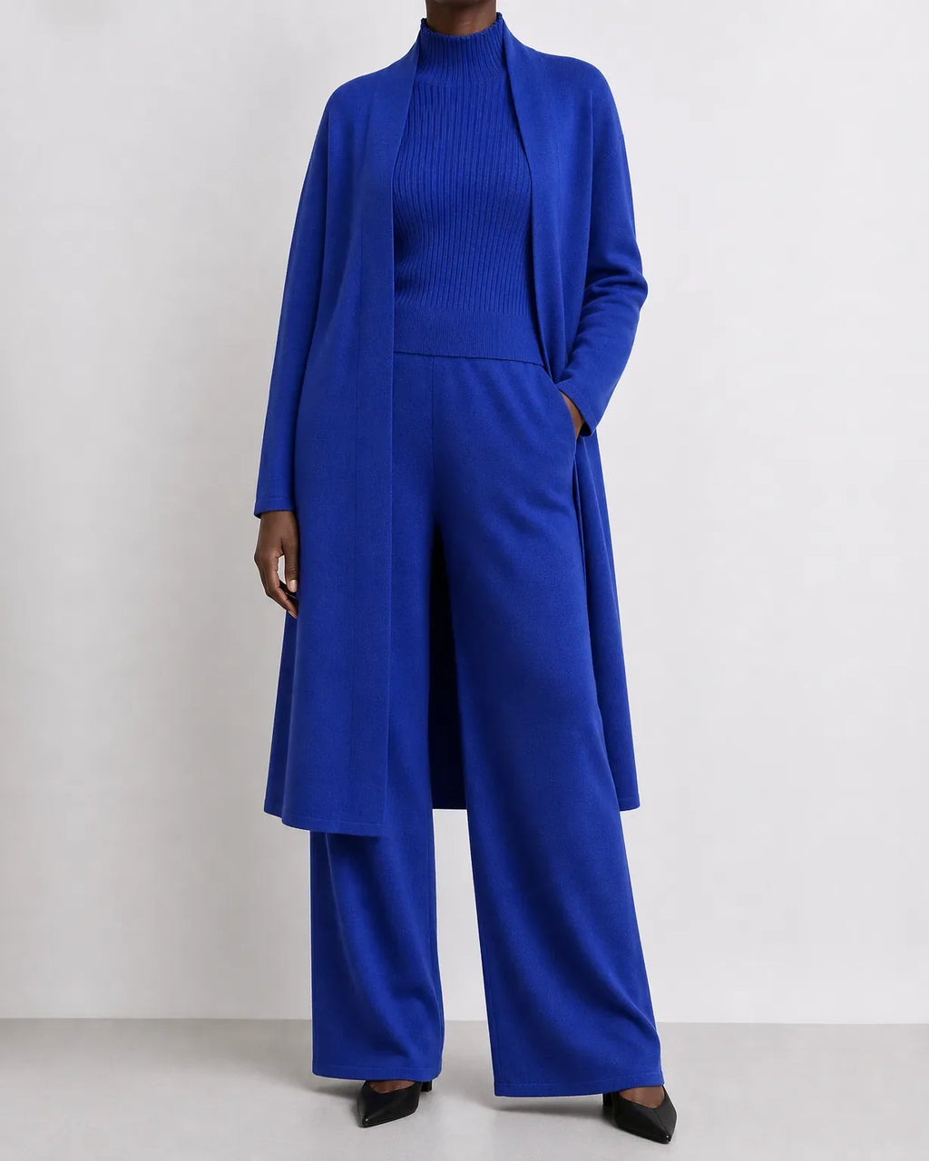 Woman wearing a three piece knit set with longline cardigan, ribbed mock-neck top and wide leg pants - view 4