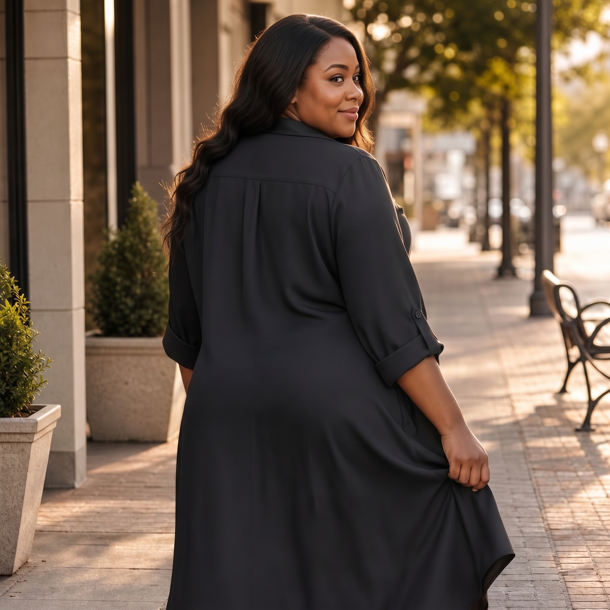 Woman wearing a long sleeve button-front shirt dress with roll-tab sleeves and a curved high-low hem - view 6