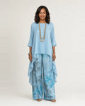 Woman wearing a two piece set with an asymmetric tunic and wide-leg floral pants
