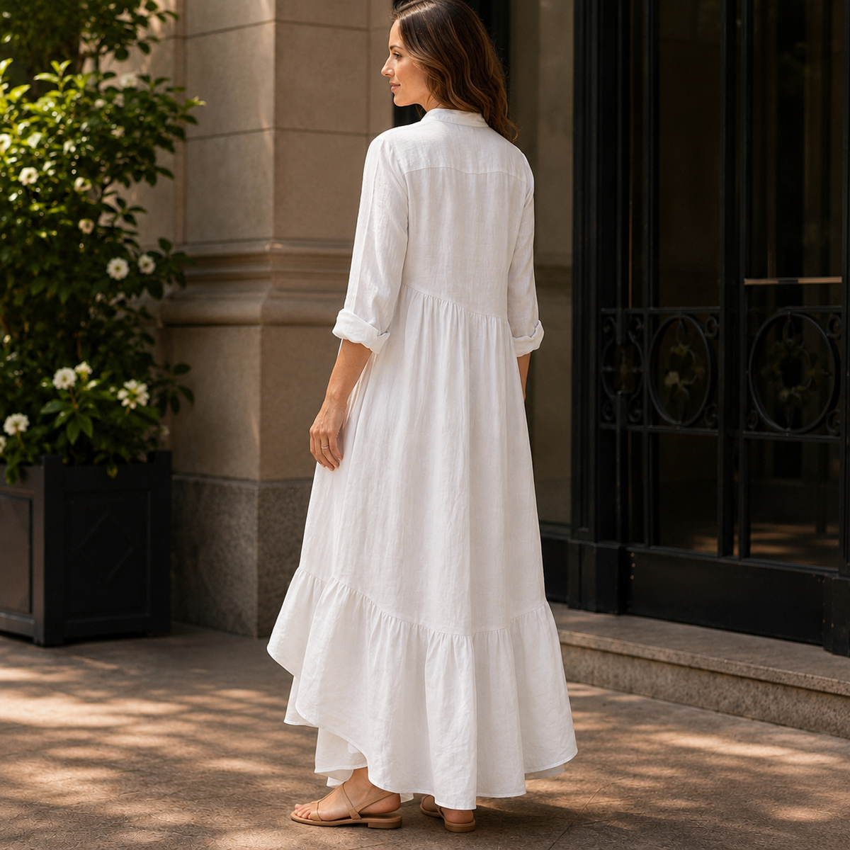 Woman wearing a long sleeve maxi dress with band collar, button placket and asymmetric ruffle hem - view 2