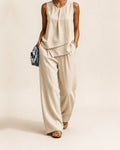 Woman wearing the Selma two piece set, a layered sleeveless top with matching wide leg pants